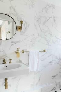 W białej łazience znajduje się umywalka i lustro. w obiekcie Château De La Bûcherie w mieście Saint-Cyr-en-Arthies
