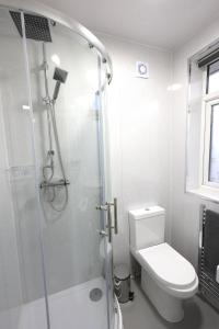 a white bathroom with a shower and a toilet at Studio 22 Lower Road Beeston in Nottingham