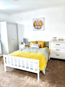 a bedroom with a white bed and a yellow blanket at Studio 22 Lower Road Beeston in Nottingham