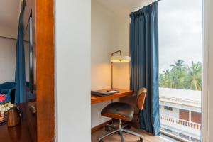 a desk with a chair next to a window at De Mandarin Candolim Beach Goa in Candolim