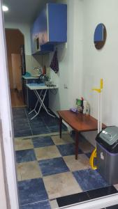 a room with a kitchen with a table and a desk at Eka's Vacation House in Batumi