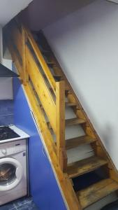 a wooden staircase in a room with a washing machine at Eka's Vacation House in Batumi