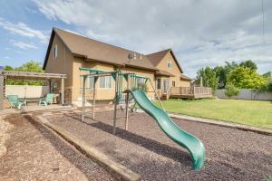 a playground with a slide in front of a house at Spacious Utah Retreat with Deck, Grill and Fire Pit! in Provo