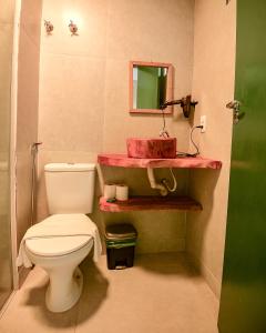 a bathroom with a white toilet and a red sink at Cocco Pousada in Maragogi