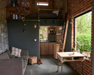 een woonkamer met een bank en een hoogslaper bij The Tiny House in Shootend