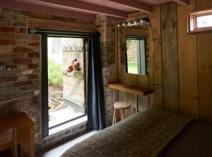 un dormitorio con un perro mirando por la ventana en The Tiny House en Shootend