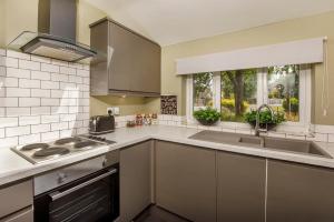 uma cozinha com utensílios de aço inoxidável e uma janela em Hollis House York- 4 bedroom with free parking em Strensall