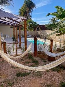 a couple of hammocks in front of a pool at Pousada Paraiso in Alto Paraíso de Goiás