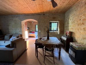 uma sala de estar com uma mesa e um sofá em Cosy Piano village cottage in Pachna em Limassol