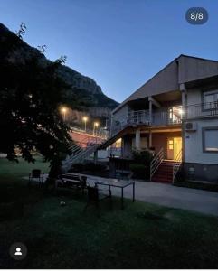 a building with a table and benches in the grass at Vila Natalija in Podgorica