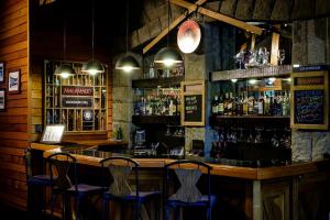 un bar avec trois chaises assises au bar dans l'établissement Bahía Manzano Resort, à Villa La Angostura