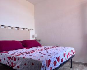 una camera da letto con un letto con una coperta rossa a cuore di L'angolo sul porto a Palau