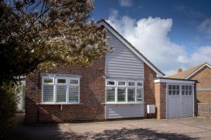 a red brick house with a garage at Number Twenty Four in West Wittering