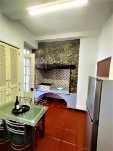 a kitchen with a table and a refrigerator at Fort Traditional Guest House in Funchal +17 photos