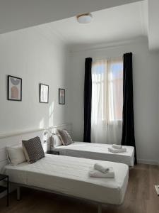 1 dormitorio con 2 camas y ventana en Express by gaiarooms, en Barcelona