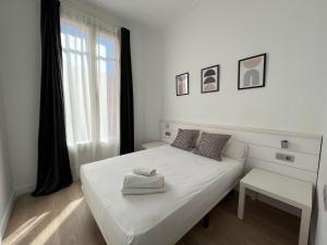 a white bedroom with a white bed and a window at Express by gaiarooms in Barcelona