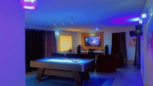 a living room with a pool table in the middle at Maleeks Apartment Ikeja "Shared 2Bedroom Apt, individual private rooms and baths" in Lagos