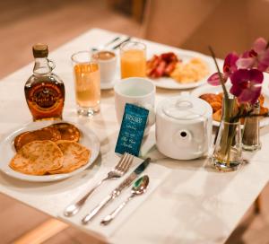 una mesa con platos de comida y una botella de whisky en Golden Tulip Aix les Bains - Hotel & Spa en Aix-les-Bains