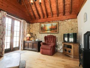 uma sala de estar com uma cadeira e uma televisão em Bolton Barn em Lenham