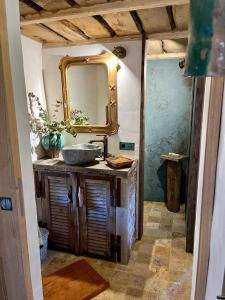 La salle de bains est pourvue d'un lavabo et d'un miroir. dans l'établissement Magnifique Bergerie Passione vue panoramique mer et maquis, à Cargèse