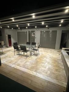 a dining room with a table and chairs on a tile floor at Magic View 4U in Kineta