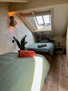 - une chambre mansardée avec 2 lits et une fenêtre dans l'établissement Magnifique Bergerie Passione vue panoramique mer et maquis, à Cargèse