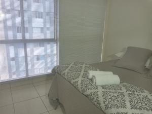 ein Schlafzimmer mit einem Bett mit zwei Handtüchern darauf in der Unterkunft Espetacular apartamento no centro in Curitiba