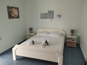 a bedroom with a white bed with two towels on it at Active and Healthy Life Style in Zipárion