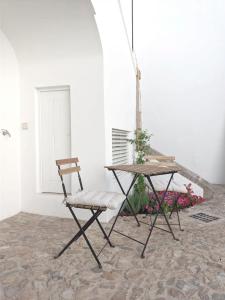 uma mesa e uma cadeira sentadas ao lado de uma mesa em Casa Pátio do Megué em Évora