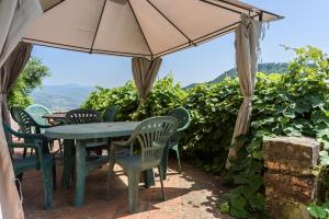 a table and chairs under an umbrella in a vineyard at Villa Feraldi in Scopeti