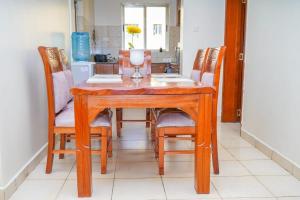 mesa de comedor con 4 sillas y mesa en Lux Suites Greatwall Getaway Apartments, en Machakos
