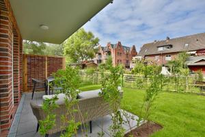 eine Terrasse mit einer Bank und einen Hof mit Gebäuden in der Unterkunft Haus Sophie - Wohnung 2 mit Terrasse in Wangerooge
