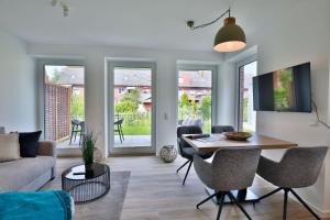 ein Wohnzimmer mit einem Tisch und einem Sofa in der Unterkunft Haus Sophie - Wohnung 2 mit Terrasse in Wangerooge