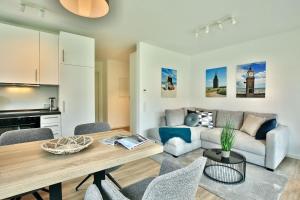 ein Wohnzimmer mit einem Tisch und einem Sofa in der Unterkunft Haus Sophie - Wohnung 2 mit Terrasse in Wangerooge