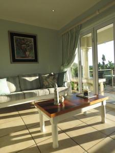 a living room with a couch and a coffee table at Mangrove Beach Estate - 3 Mtwalume in Port Shepstone