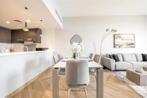 cocina y sala de estar con mesa y sillas en Ultra Luxury Wasl 1 Residences Zabeel Park, en Dubái
