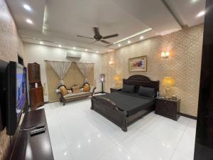 een slaapkamer met een bed en een flatscreen-tv bij Stylish Vacation Home in DHA near Airport in Lahore