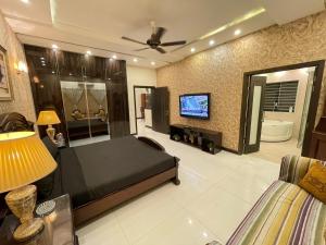 een slaapkamer met een bed en een tv in een kamer bij Stylish Vacation Home in DHA near Airport in Lahore