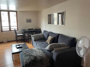 Una sala de estar con un sofá azul y una mesa. en Duplex Cosy 85 m2 hyper centre Châlons-en-Champagne, en Châlons-en-Champagne