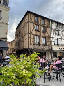 a group of people sitting at tables in front of a building at Duplex Cosy 85 m2 hyper centre Châlons-en-Champagne in Châlons-en-Champagne