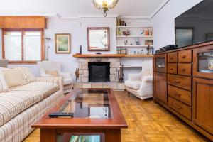 ein Wohnzimmer mit einem Sofa und einem Kamin in der Unterkunft Casa con jardín privado Oreña in Oreña