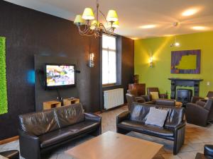 uma sala de estar com mobiliário de couro e uma televisão em Spacious holiday home in Noiseux with garden em Noiseux