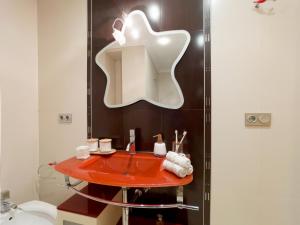 a bathroom with a red sink and a mirror at Acogedor ático en Salamanca by beBalmy in Salamanca