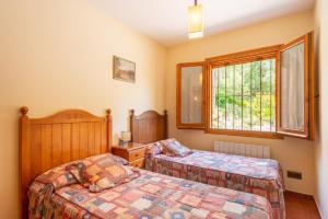 巴塞隆納的住宿－Can Caldeta - Naturaleza y privacidad en el Montseny，一间卧室设有两张床和窗户。