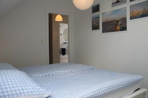 Bett in einem weißen Zimmer mit Spiegel in der Unterkunft Büsumer Ferien Alleestraße in Büsum