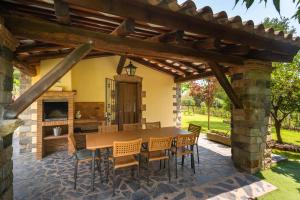a patio with a wooden table and chairs under a pergola at Can Caldeta - Naturaleza y privacidad en el Montseny in Barcelona