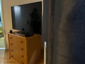 a flat screen tv sitting on a wooden dresser at Entire Flat, Canterbury Centre - Free Parking in Kent