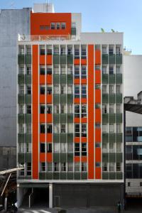 聖保羅的住宿－Tabas - Edifício Arinda - São Paulo，公寓大楼设有橙色和绿色的窗户。