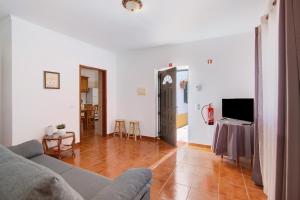 a living room with a couch and a television at Quinta Alegre Tavira T2 in Luz de Tavira