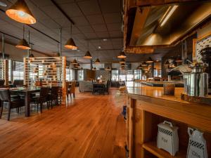 a restaurant with wooden floors and tables and chairs at Nice holiday home in Hellendoorn with terrace in Hellendoorn